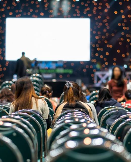 Rear view of Audience in the conference hall or seminar meeting which have Speakers